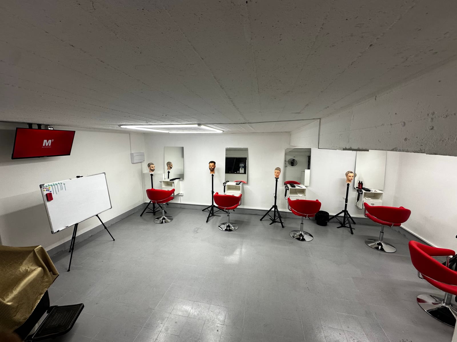 Vista general del salón de la Academia con estaciones y sillas rojas
